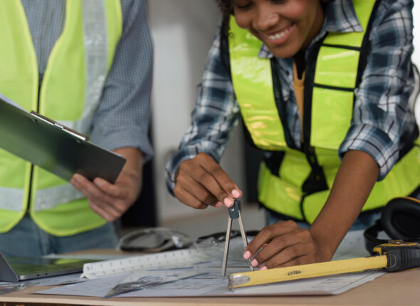 Architect team working with blueprints for architectural plan, engineer sketching a construction project on table in working site